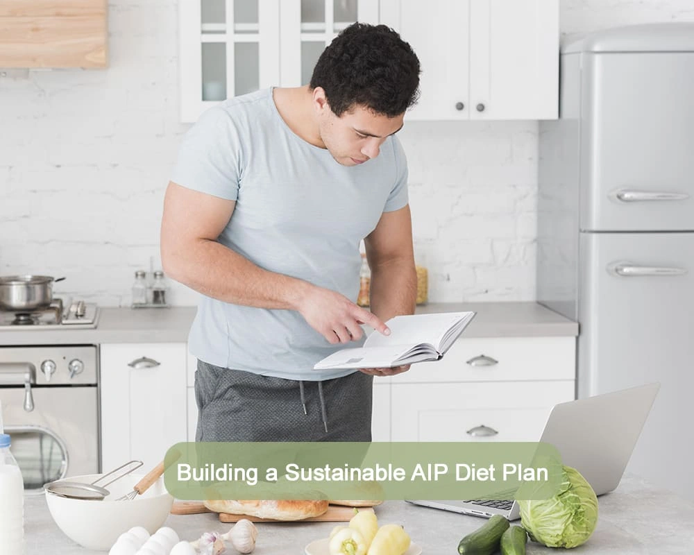Man in kitchen reading a cookbook while planning an AIP (Autoimmune Protocol) diet with fresh vegetables and a laptop on the counter